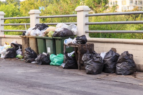 Waste collection workers managing bins in a busy London area